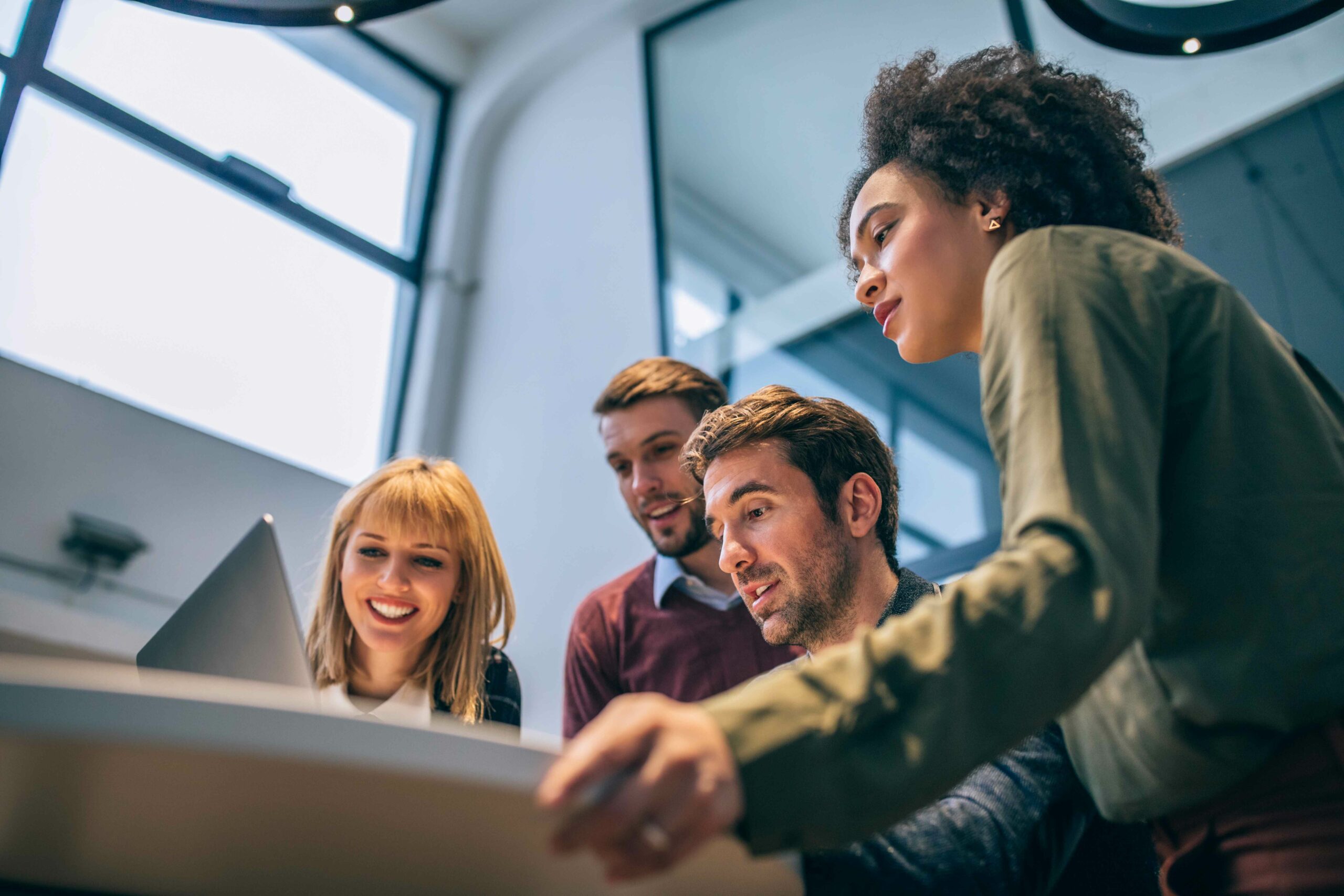 Low angle shot of coworkers looking at a laptop computer